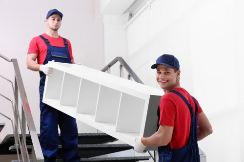 Skilled movers preparing furniture for transport in Merton
